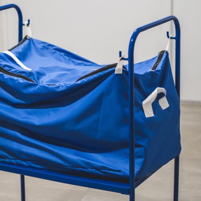 Carro de transporte metálico RTP Radom equipado con una bolsa textil azul con cremallera, utilizado en la logística profesional de lavanderías.